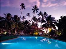 Hotel Tropical. piscina y cocoteros al atardecer